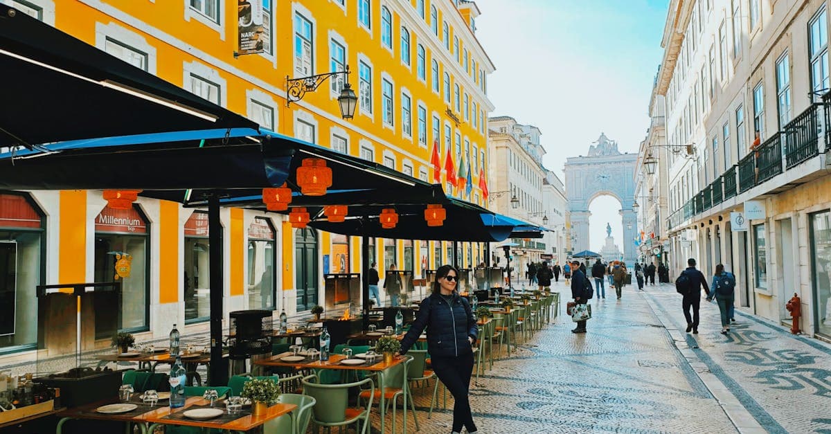 Rua movimentada de Lisboa com arquitetura histórica e café típico português