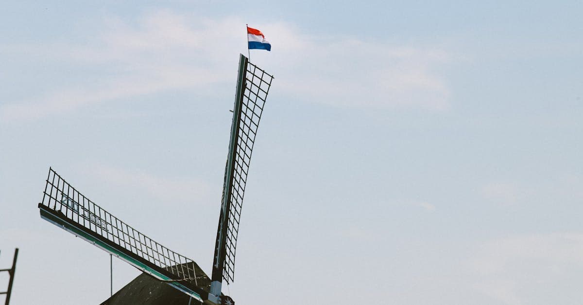 Traditionele Nederlandse windmolen met de vlag van Nederland, symbool van een land met goede prepaid simopties