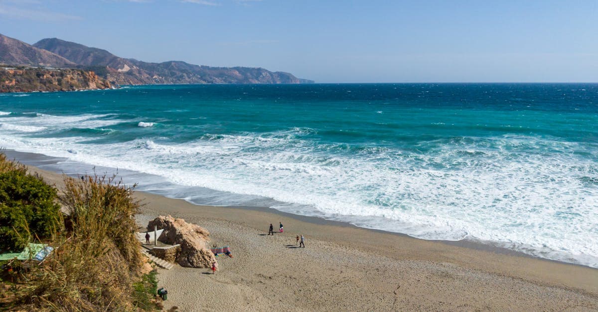 Vista aerea della spiaggia di Nerja in Spagna con acque turchesi, meta low cost 2026