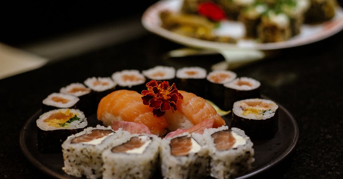 Prato de sushi com nigiri e rolos decorados elegantemente, mostrando ingredientes da culinária japonesa