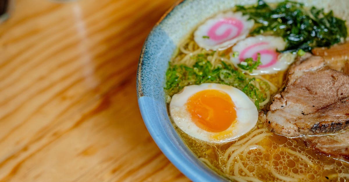 木のテーブルに盛られた卵とトッピング付きの濃厚な札幌ラーメン、best ramen sapporoの歴史を語る一杯
