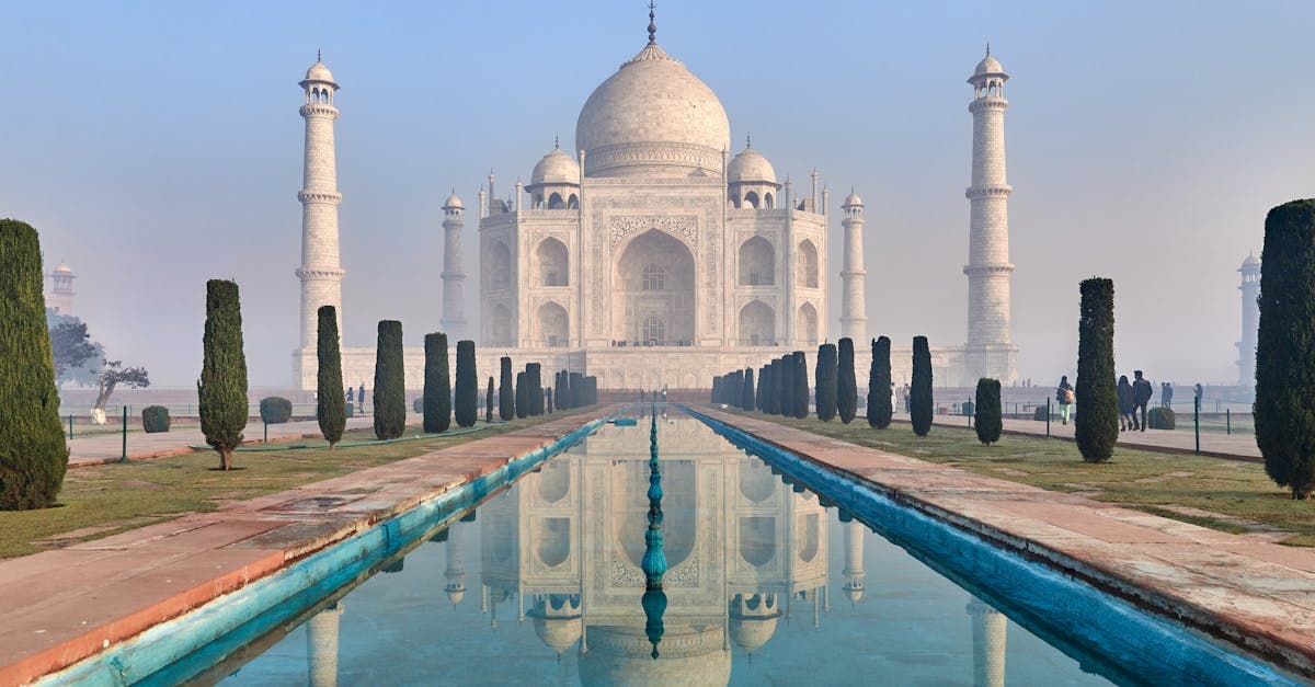 Icónico Taj Mahal reflejado en agua demostrando belleza arquitectónica para planificación de viajes a India