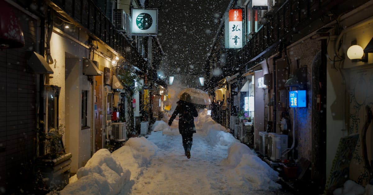 Seorang wisatawan berjalan di gang bersalju Kanazawa malam hari, gambaran nyata suhu rata-rata cuaca jepang musim dingin