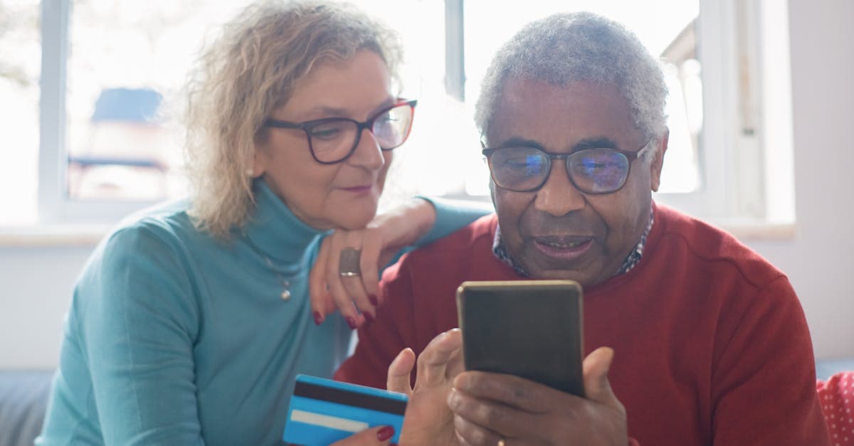 Couple de voyageurs seniors utilisant un smartphone pour gérer leur connexion internet à l'étranger
