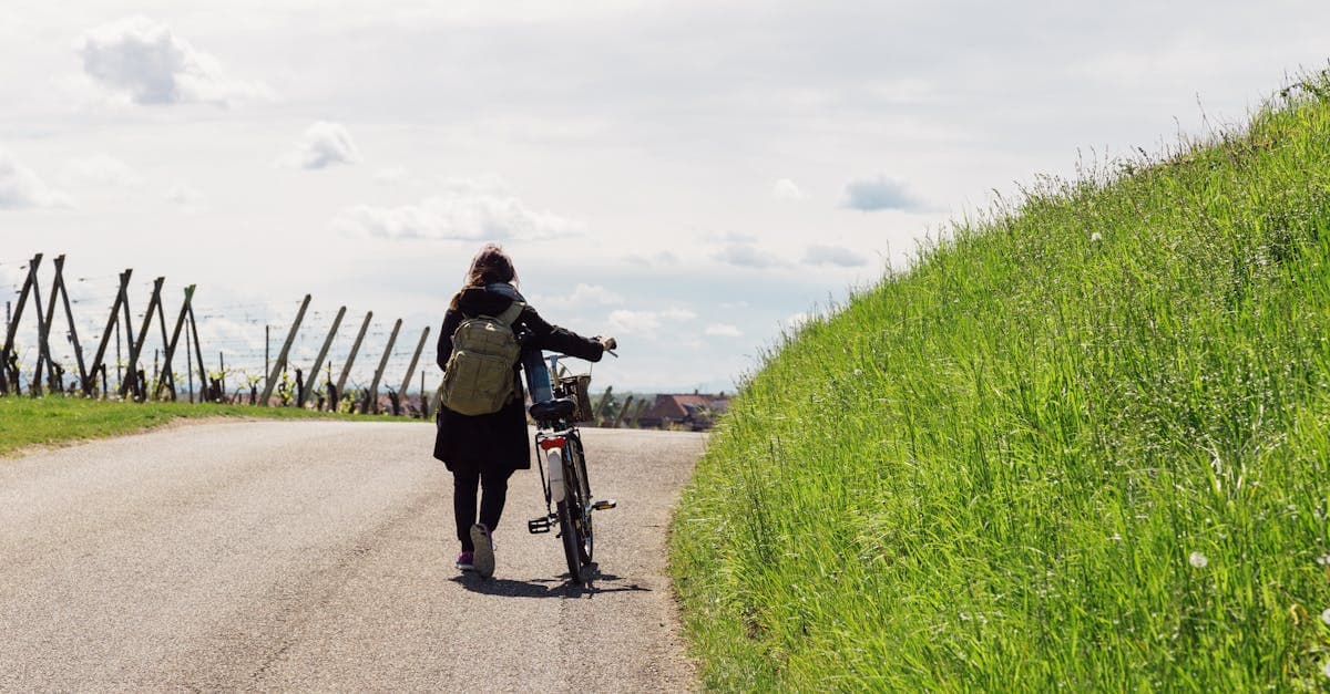 Woman cycling alone along a scenic European country road, the best way to solo travel Europe