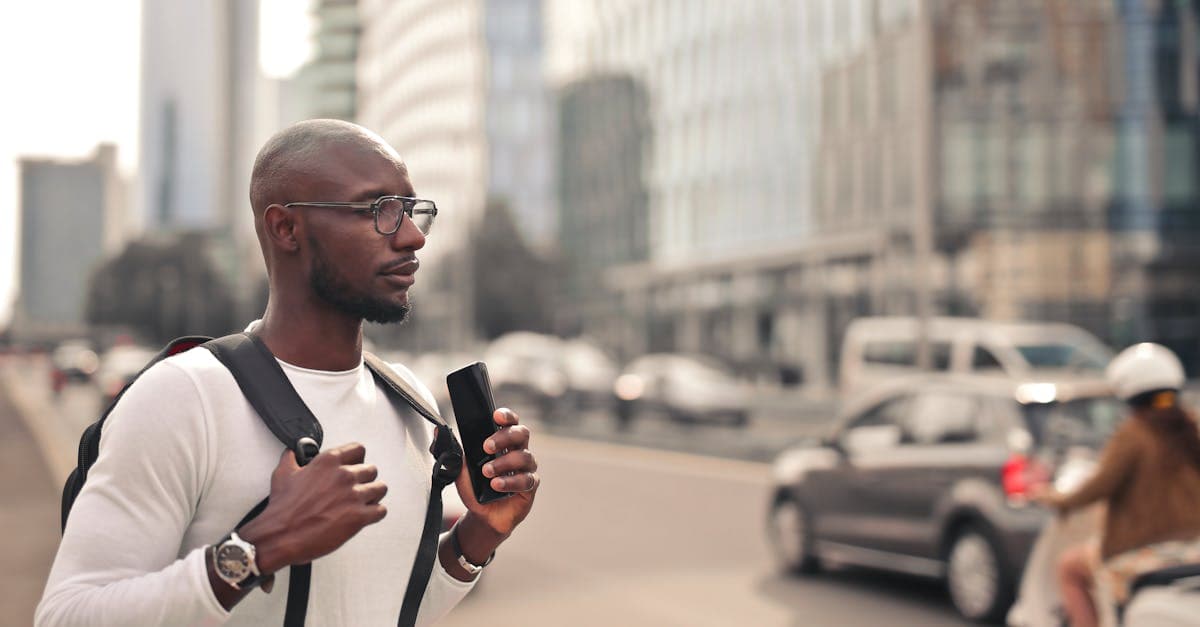 Man walking through Milan checking smartphone data usage to monitor and control his roaming costs abroad