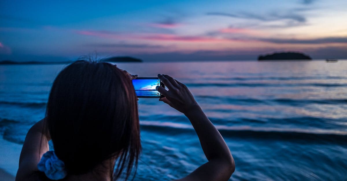 Traveler photographing a stunning ocean sunset in Cancun using a smartphone with a travel eSIM