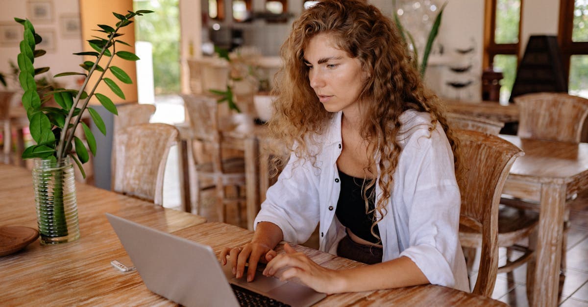 Woman with curly hair working on laptop inside a classic Bali restaurant with reliable wifi