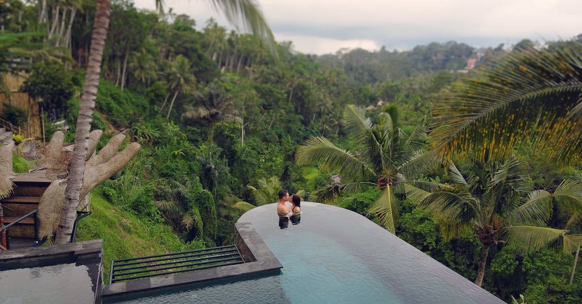 New Zealand couple relaxing in a Bali infinity pool overlooking lush tropical jungle