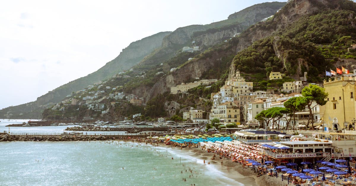 Sunbathers and colourful umbrellas on the Amalfi Coast, Italy, one of Europe's cheapest holiday destinations