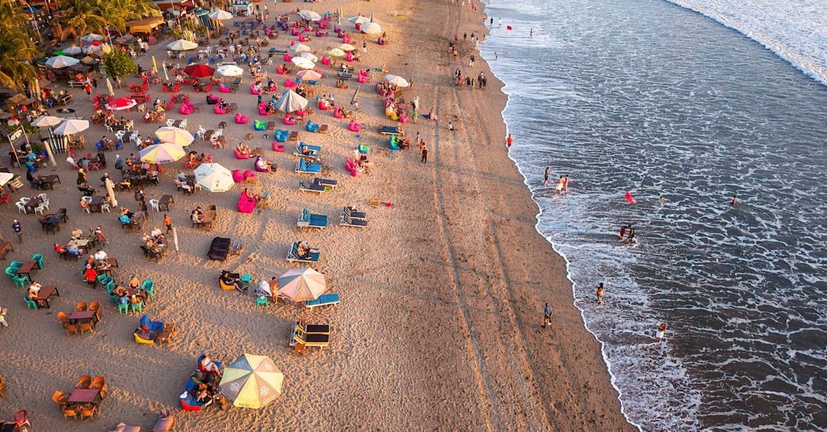 Vibrant aerial sunset over a crowded Bali beach, helping New Zealanders plan their Bali trip budget