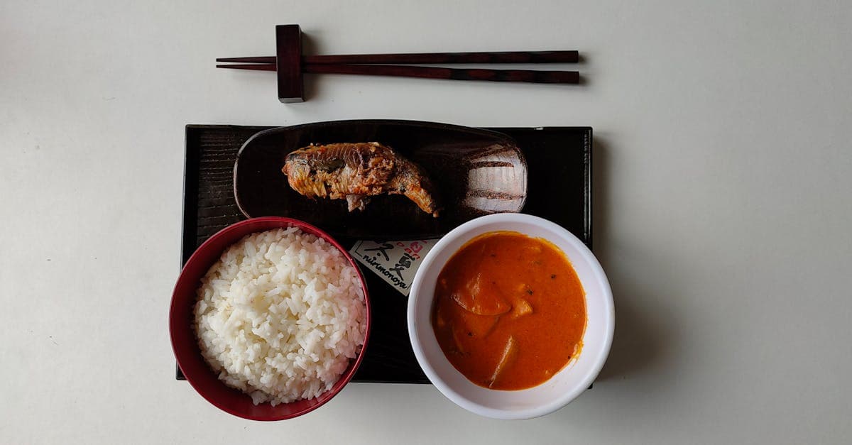 Almoço japonês completo com arroz, curry e peixe gralhado servido com hashis, refeição típica do dia a dia.