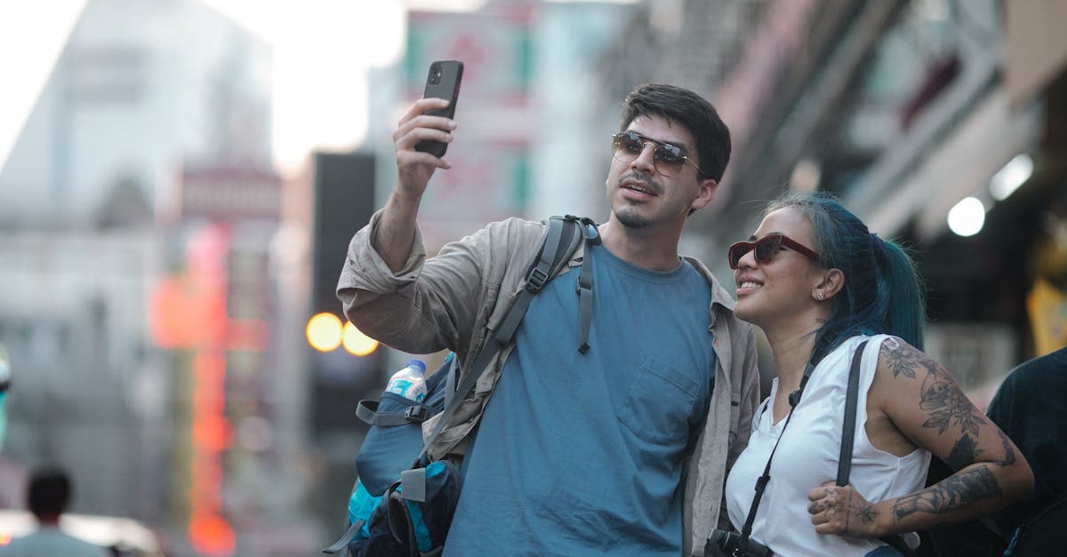 คู่บุคคลยิ้มแย้มถ่ายเซลฟี่บนถนนเมืองช่วง thailand rainy season ท่องเที่ยวและสร้างความทรงจำ
