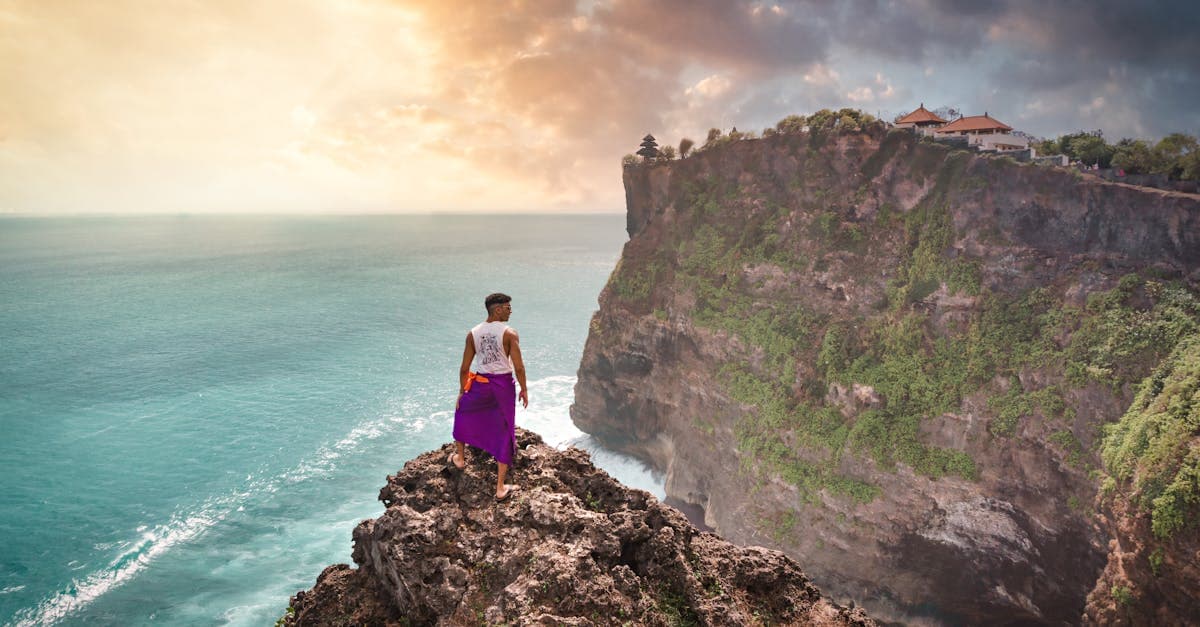 Traveller overlooking Uluwatu Temple clifftops at sunset, staying connected with a travel eSIM for Bali