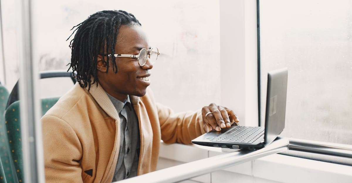 Young commuter using laptop on the go, testing whether portable wifi devices deliver reliable speeds in India
