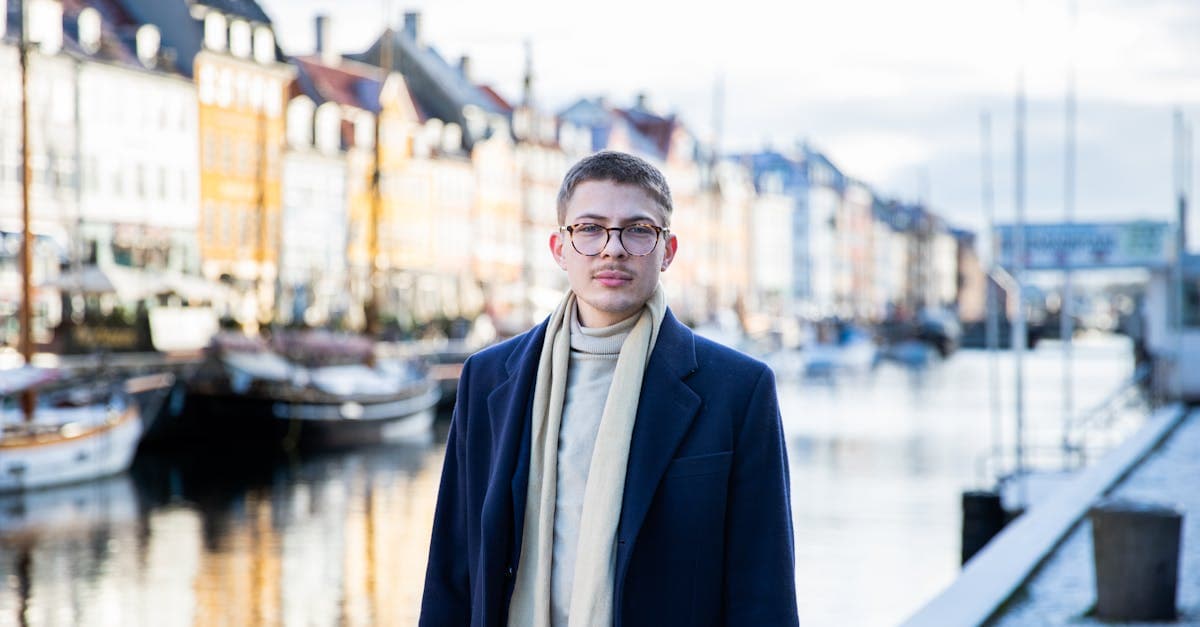 Ung mand i jakkesæt ved Nyhavn Canal overvejer mulighederne for at arbejde i udlandet og skatteforhold.