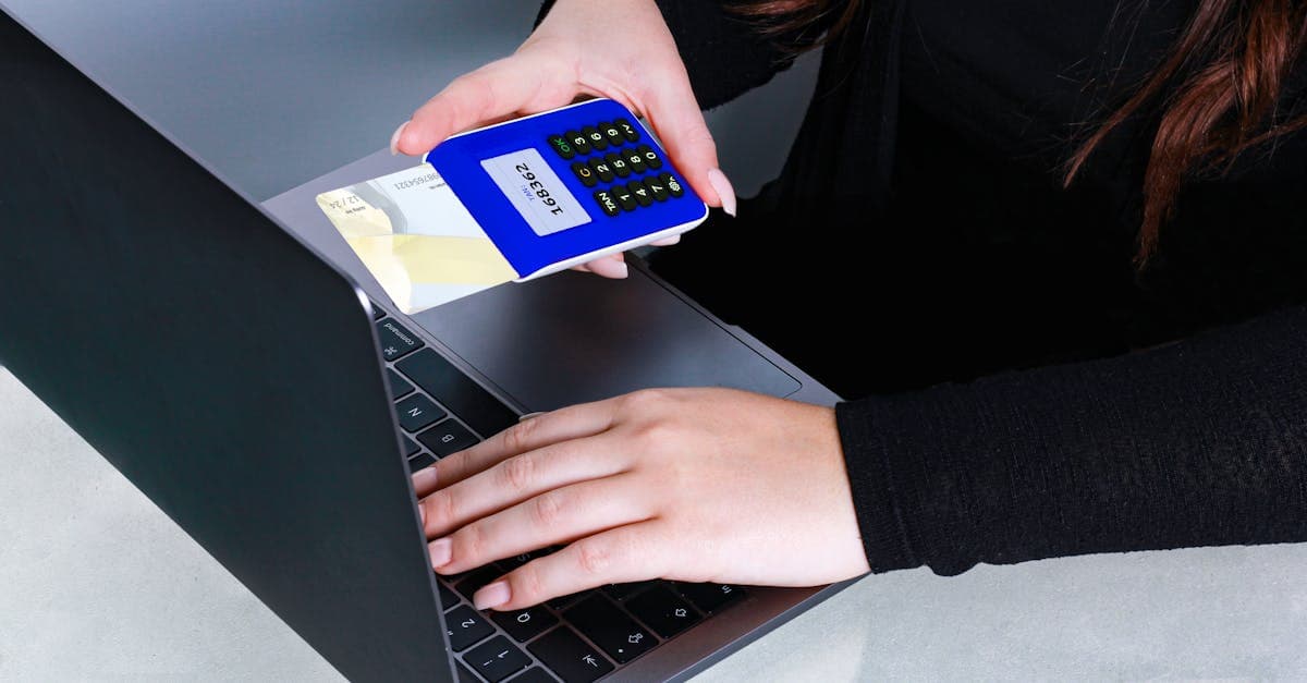 Person using card reader and laptop for secure online payment, showcasing modern cashless technology.