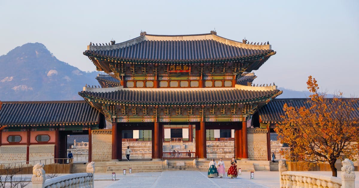 Kiến trúc truyền thống cung điện Gyeongbokgung với núi non hùng vĩ phía sau lúc hoàng hôn.