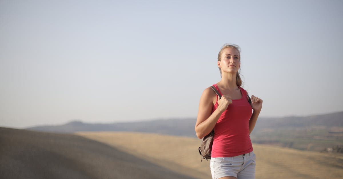 Confident solo female hiker on scenic hills, applying practical traveling alone tips for women