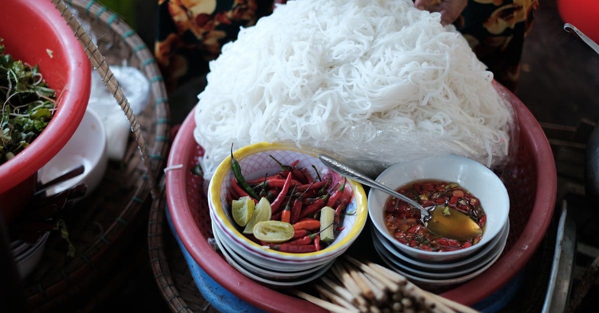 Nouilles vietnamiennes aux herbes fraîches, piments et nuoc-mam dans un marché animé de Hué
