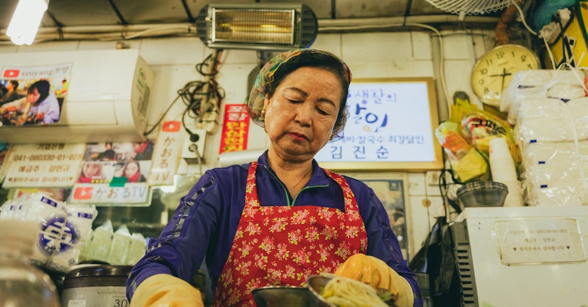 Bustling Korean street food market in Seoul with vendors preparing traditional dishes amid vibrant, crowded stalls.