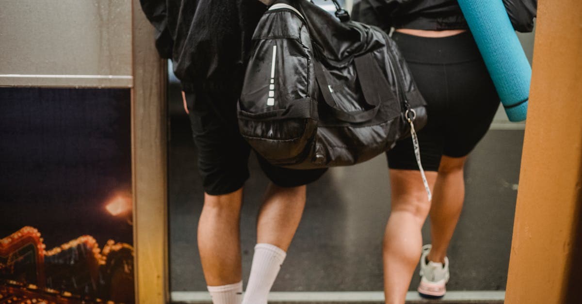 Man och kvinna stiger på tunnelbana med duffelväska, jämför handbagage för SAS och Norwegian 2026.