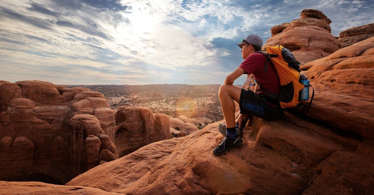 Backpacker applying solo travel tips while exploring Moab, Utah's red rock formations at sunrise.