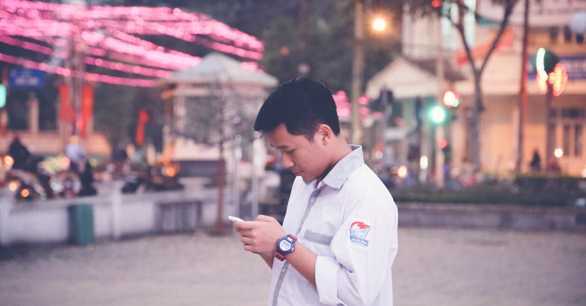 Chàng trai dùng điện thoại trên phố đô thị lúc hoàng hôn, đăng ký chuyển vùng quốc tế Vinaphone trước khi bay.