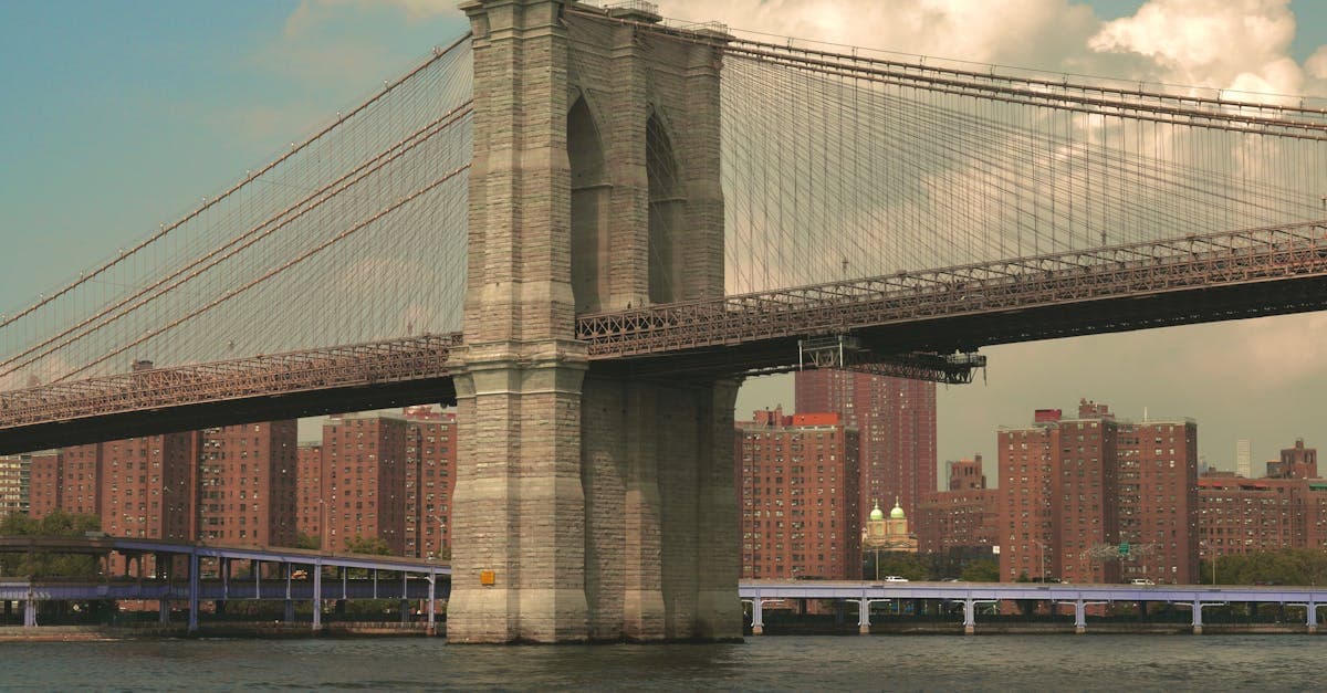 A classic view of the iconic Brooklyn Bridge with New York City's urban landscape in the background.
