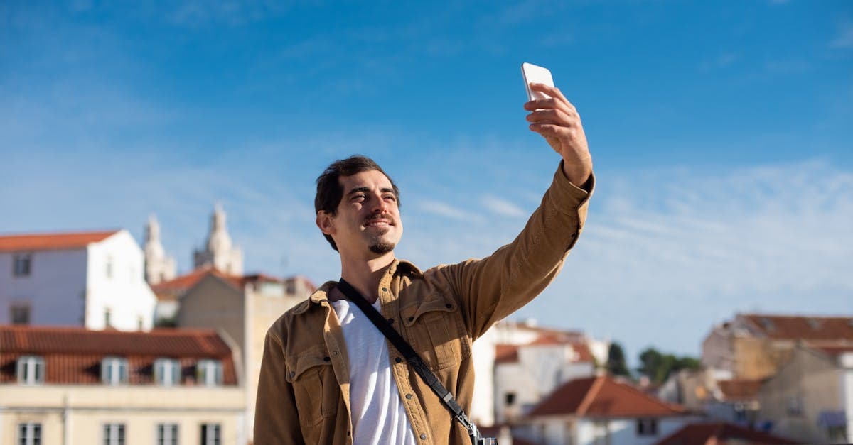 Homem tirando selfie em cidade europeia ensolarada verificando a compatibilidade do celular com eSIM