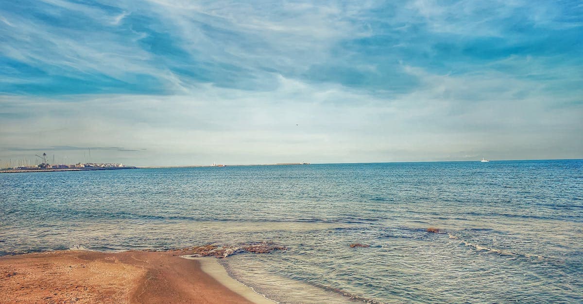 Scenic view of a serene Spanish beach with azure waters under a clear blue sky, perfect for travel and relaxation.