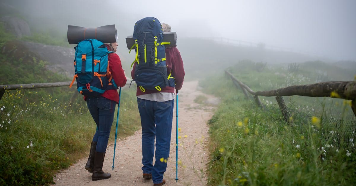 Dois mochileiros em trilha enevoada em Portugal, explorando a Europa na melhor época do ano.