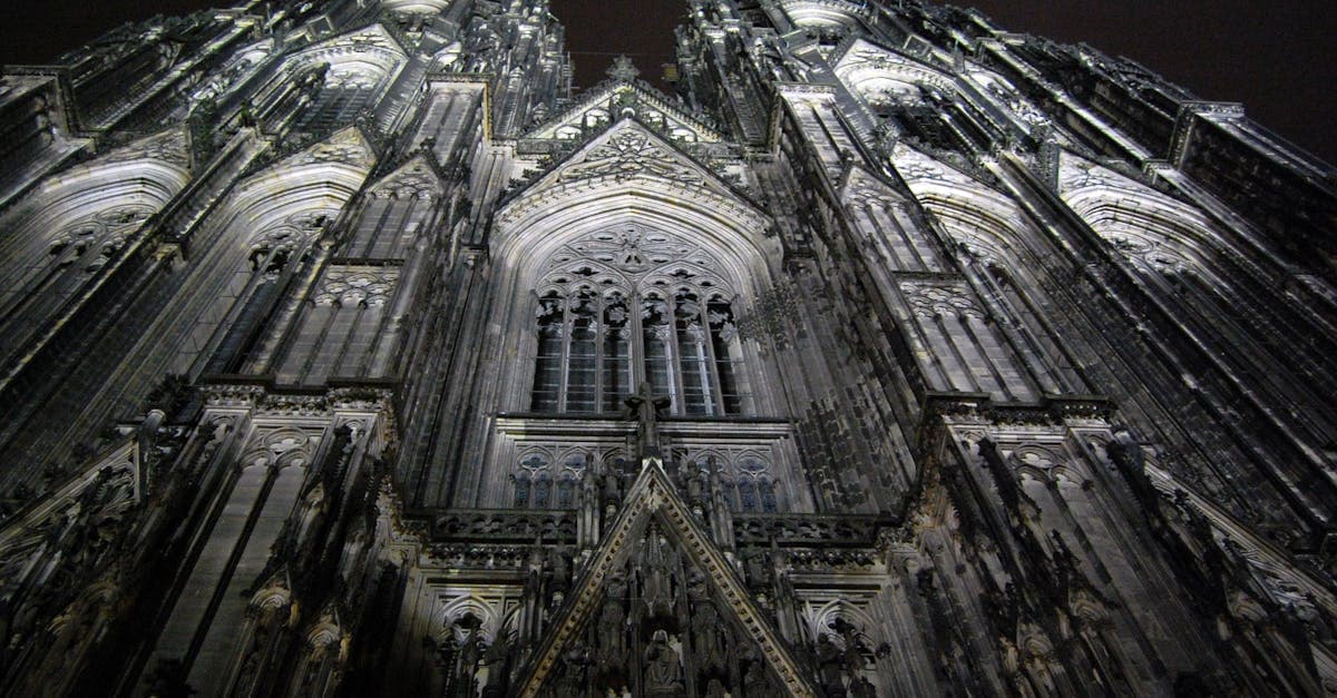 Striking architectural view of Cologne Cathedral at night showcasing Gothic design details.