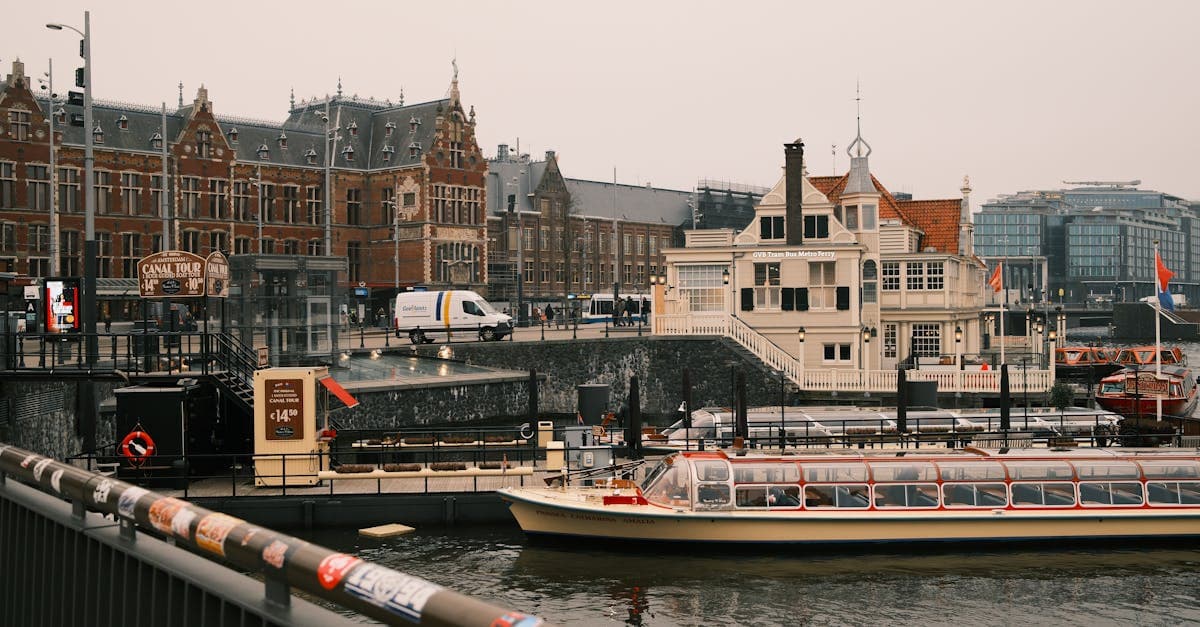 Amsterdamse gracht met rondvaartboten en historische architectuur, de ideale stad om een prepaid sim card netherlands te kopen