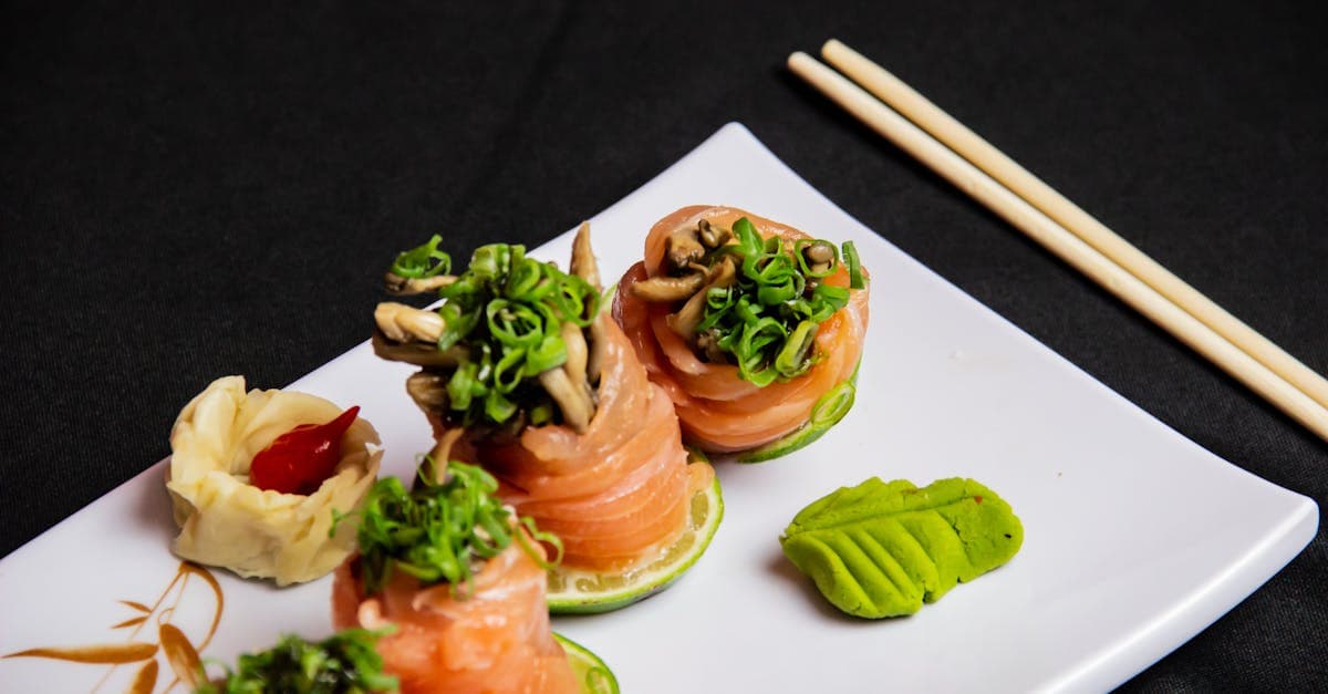 Prato artístico de sushi de salmão com wasabi e pauzinhos sobre fundo branco