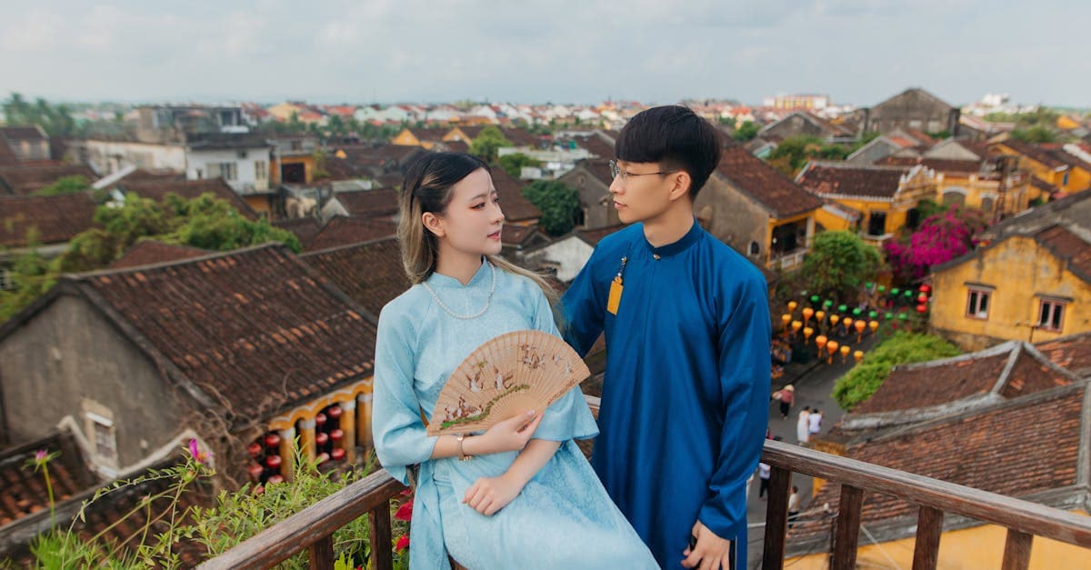 Cặp đôi mặc trang phục truyền thống nhìn ra mái nhà Hội An, tìm hiểu bảng giá gói cước roaming Vinaphone 2026.