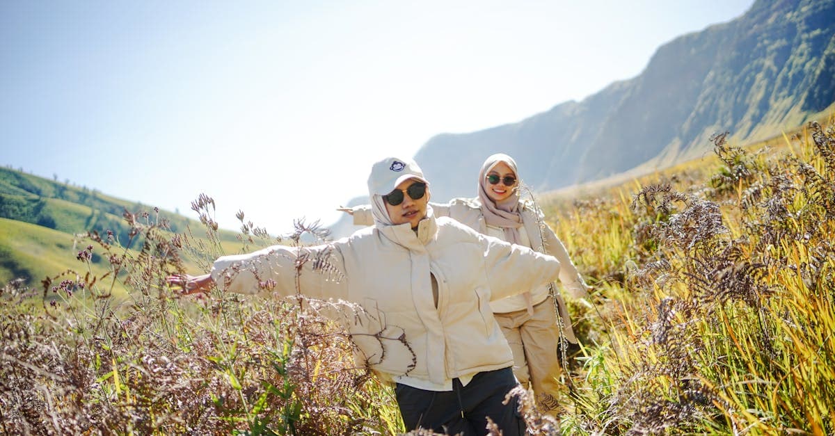 Dua sahabat menjelajahi sabana Gunung Bromo dengan ceria, perjalanan aman berkat asuransi perjalanan yang tepat.