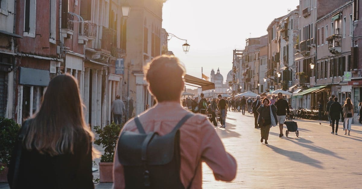 Travelers strolling through Venice's historic streets at sunset, staying connected with eSIM Europe solutions